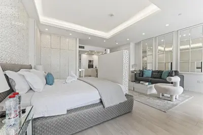 a bedroom with a large bed and a living room at Beachfront Studio JBR - Murjan 2 by Home Of Choice in Dubai