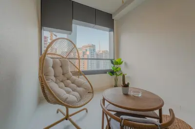 a rattan chair and a table in a room with a window at C&L Homes with Burj Khalifa view in Dubai