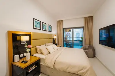 a bedroom with a large bed and a television at C&L Homes with Burj Khalifa view in Dubai