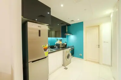 a kitchen with a refrigerator and a washing machine at C&L Homes with Burj Khalifa view in Dubai