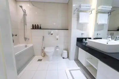a white bathroom with a sink and a toilet at C&L Homes with Burj Khalifa view in Dubai