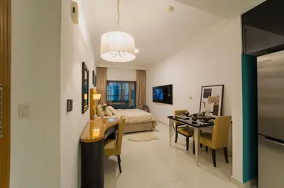 a room with a dining table and a bedroom at C&L Homes with Burj Khalifa view in Dubai