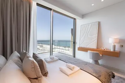 a bedroom with a bed with a large window at Ultra Luxury 2BD Beachfront & Panoramic Sea Views in Dubai
