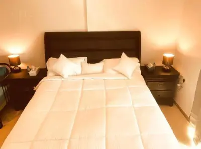 a bedroom with a large white bed with two night stands at Royal Marina Inn in Dubai