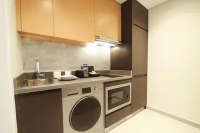 a kitchen with a sink and a washing machine at A luxurious 1 bedroom and living room in Dubai