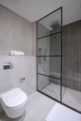 a bathroom with a shower and a toilet at Waterfront Luxe Haven Peninsula in Dubai