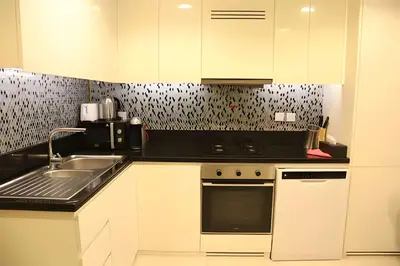 a kitchen with a sink and a stove top oven at Stunning 2 Bedroom Aykon City Tower C in Dubai