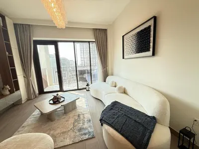 a living room with a white couch and a table at Luxury 1BR I Creek Beach I Pool & Beach in Dubai