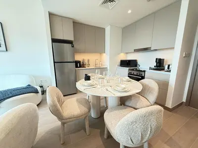 a kitchen with a table and chairs in a kitchen at Luxury 1BR I Creek Beach I Pool & Beach in Dubai