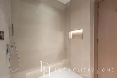 a bathroom with a shower with a shower at LUX The Burj Khalifa Lagoon View Suite 5 in Dubai