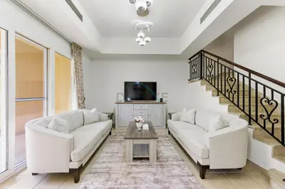 a living room with two white couches and a tv at Serene 2BR Villa, Minutes Drive to Miracle Garden and Dubai Butterfly Garden, Steps from Golf Course, Palmera 2, Arabian Ranches by Deluxe Holiday Homes in Dubai