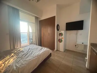 a bedroom with a bed and a flat screen tv at Burj Sabah in Dubai