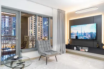 a living room with a tv and a large window at Burj Khalifa District Luxury Apartment - Downtown Dubai in Dubai