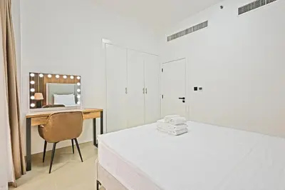 a bedroom with a bed and a desk with a mirror at Spacious 4BR in JBR Steps to Beach & Walk in Dubai