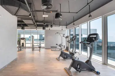a gym with treadmills and ellipticals in a room with windows at Spacious 4BR in JBR Steps to Beach & Walk in Dubai