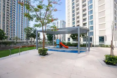 a park with a playground with a red slide at Vogue Creek Harbour Icon Bay Waterfront Living Close to Downtown, Burj Khalifa and Dubai Mall, Three Bedroom Apartment with Large Balcony, Canal and Burj Khalifa View, Access to all Amenities in Dubai