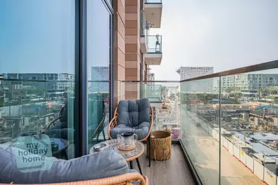 a balcony with chairs and a table on a building at Burj Khalifa View from Roof-Pool & Gym -Parking in Dubai