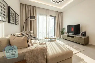 a living room with a couch and a tv at Burj Khalifa View from Roof-Pool & Gym -Parking in Dubai