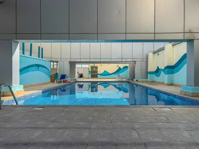 a large swimming pool in a large building at Modern Cozy Studio Near Dubai Marina in Dubai
