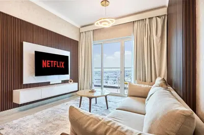 a living room with a couch and a tv at 2 Bedroom Apartment Close to Miracle Tower in Dubai
