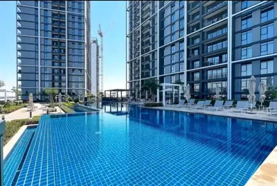 a large swimming pool in a city with tall buildings at Vogue Creek Harbour Edge Tower Waterfront Living Close to Downtown, Burj Khalifa and Dubai Mall, One Bedroom Apartment with Balcony and Canal View, Access to all Amenities in Dubai