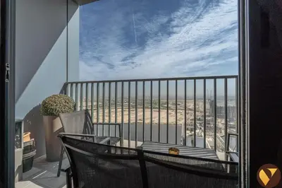 a balcony with a chair and a view of the city at Vogue Creek Harbour Edge Tower Waterfront Living Close to Downtown, Burj Khalifa and Dubai Mall, One Bedroom Apartment with Balcony and Canal View, Access to all Amenities in Dubai