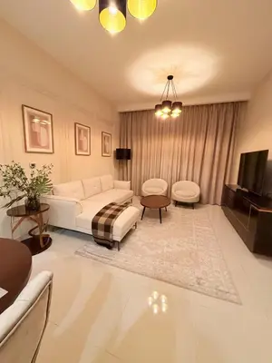 a living room with a white couch and a tv at Luxury Living In JVC in Dubai