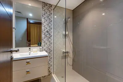 a bathroom with a sink and a glass shower at Golf Promenade 2-B, Damac Hills - 2BR Apartment - Allsopp & Allsopp in Dubai