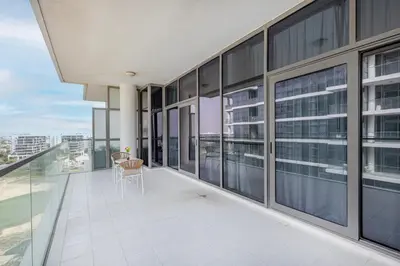 a balcony with a table and chairs in a building at Golf Promenade 2-B, Damac Hills - 2BR Apartment - Allsopp & Allsopp in Dubai