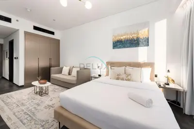 a white bedroom with a large bed and a couch at Studio Just Minutes Drive to Downtown Dubai Top Attractions, Close to Zabeel Stadium, O10 Building, Al Jaddaf by Deluxe Holiday Homes in Dubai