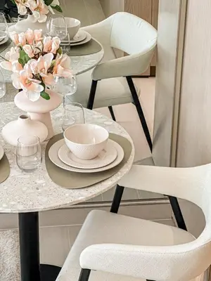 a dining room table with plates and flowers on it at WelHome - Perfect Cozy Studio with Pool, Gym & Balcony in Dubai