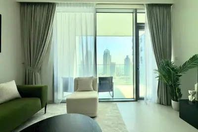 a living room with a chair and a large window at Modern 1 Bed Apartment with full Dubai Marina view in Dubai