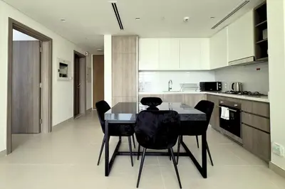 a kitchen with a dining table and black chairs at Modern 1 Bed Apartment with full Dubai Marina view in Dubai