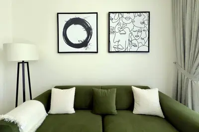 a living room with a green couch and two pictures at Modern 1 Bed Apartment with full Dubai Marina view in Dubai