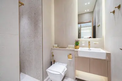a bathroom with a white toilet and a sink at Binghatti Phantom! Private Pool in Your Balcony! 5 Star Hotel Amenities! in Dubai