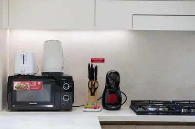 a kitchen counter with a microwave next to a stove at Binghatti Phantom! Private Pool in Your Balcony! 5 Star Hotel Amenities! in Dubai