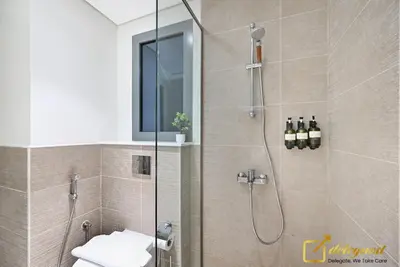 a bathroom with a shower with a glass door at Stylish Studio with City Views in Dubai Hills in Dubai