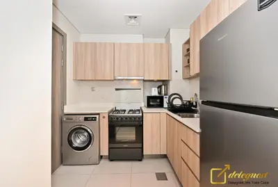 a kitchen with a stove and a washer and dryer at Stylish Studio with City Views in Dubai Hills in Dubai