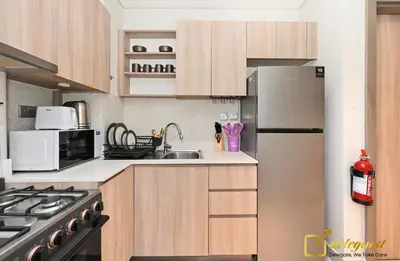 a kitchen with wooden cabinets and a stainless steel refrigerator at Stylish Studio with City Views in Dubai Hills in Dubai