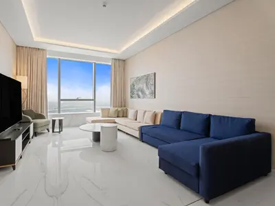 a living room with a blue couch and a tv at Luxe Island Retreat 1BR in Palm-14 in Dubai
