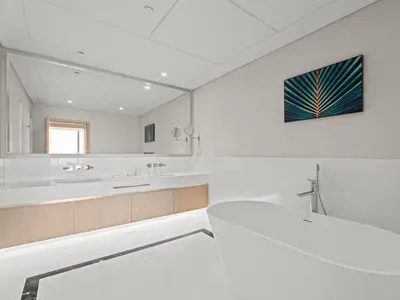 a white bathroom with a sink and a mirror at Luxe Island Retreat 1BR in Palm-14 in Dubai