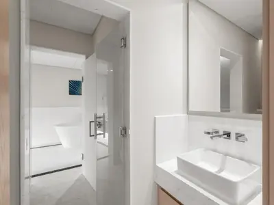 a white bathroom with a sink and a mirror at Luxe Island Retreat 1BR in Palm-14 in Dubai