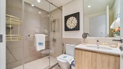 a bathroom with a shower and a toilet and a sink at 1BR Dubai Hills Executive Residence Stylish Stay in Dubai