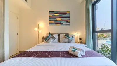 a bedroom with a large white bed with a window at 1BR Dubai Hills Executive Residence Stylish Stay in Dubai