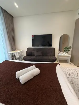 a bedroom with a large bed with two towels on it at Stylish Studio JVC I Epic Amenities I Near Mall in Dubai
