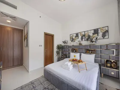 a bedroom with a bed with a table on it at Livin' Holidays - 1 BR - Elegant Apartment in Dubai