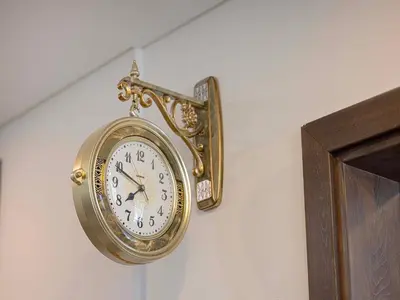 a gold clock hanging on a wall next to a door at Livin' Holidays - 1 BR - Elegant Apartment in Dubai