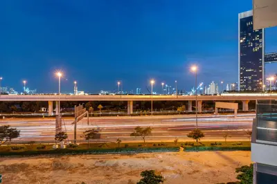 a city skyline with a highway at night at Contemporary 1BR City View Apartment at 1 Residence in Dubai