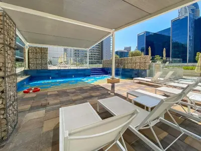 a patio with chairs and a pool on a building at Executive 1BDR Sleeps 4 In Vera-Business Bay-80 in Dubai