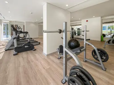 a gym with several treadmills and weights at Executive 1BDR Sleeps 4 In Vera-Business Bay-80 in Dubai